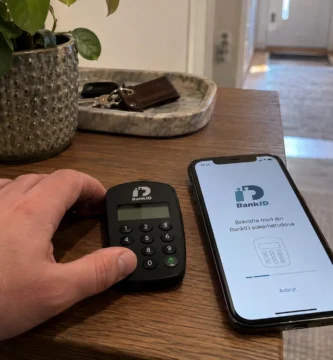 En hand vilar bredvid en mobil och BankID-dosa inför identifiering för ett svenskt nätcasino.