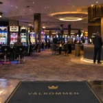 En svensk casinospelsal med spelautomater och informationsdisk visar miljön där bonusar och freespins erbjuds.